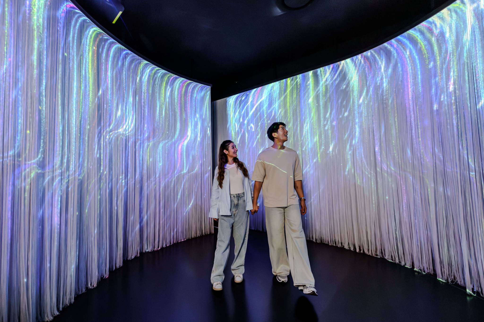 Couple Walking Through Fiber Optic Light Tunnel