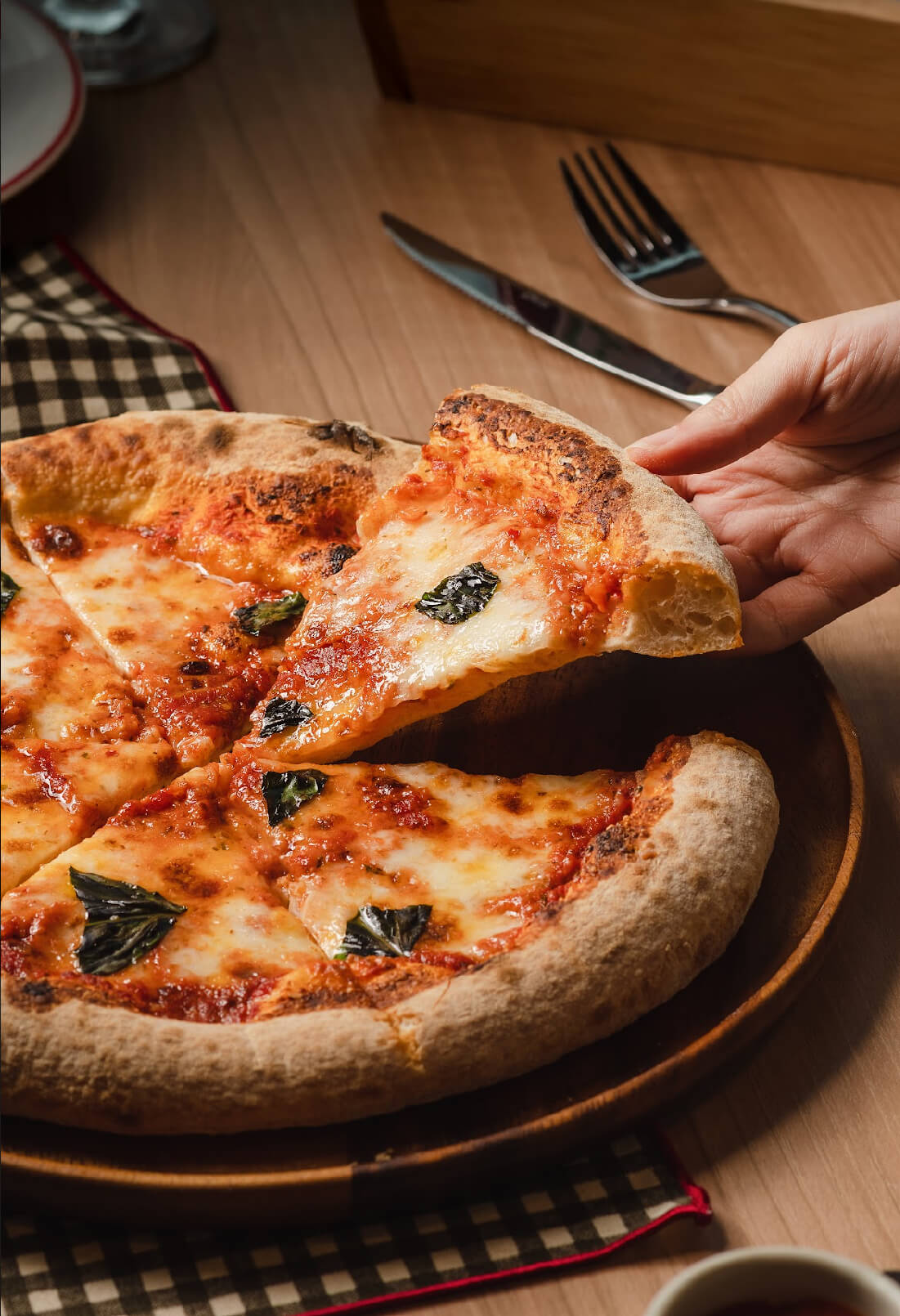 Hand Taking Slice of Margherita Pizza